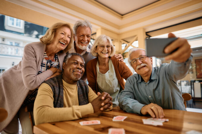 Cheerful seniors having fun while taking selfie at retirement community. stock photo