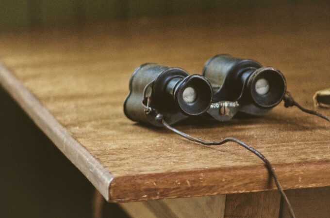binoculars on a wooden table to express the idea of Elder Care Planning Framework