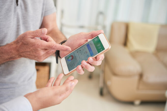 Two people look at health information on a smart phone.